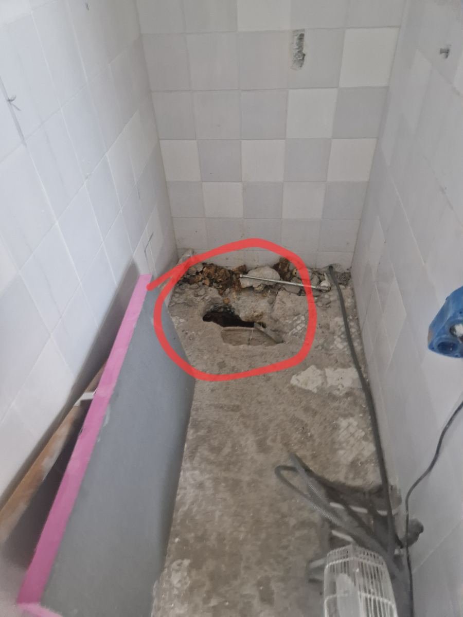 Geopende douchevloer bij onderzoek naar een lekkage in de badkamer
