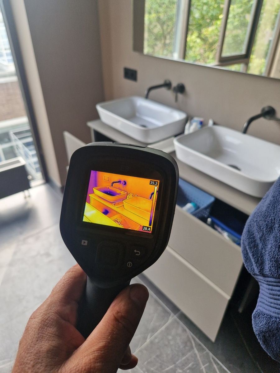 Warmtebeeldcamera in een badkamer bij een inspectie op verborgen lekkage